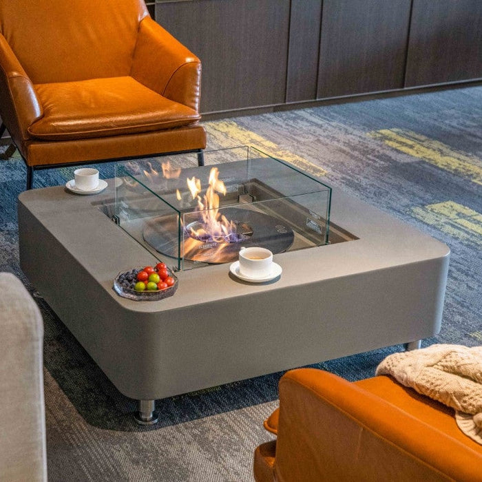 Modern living room with a Gray elementi fire pit table, orange chairs, and gray sofa.