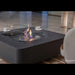 Modern fire pit table with flames in a room setting, featuring the Elementi brand.