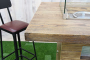 Wooden bar table with a high chair on a green surface
