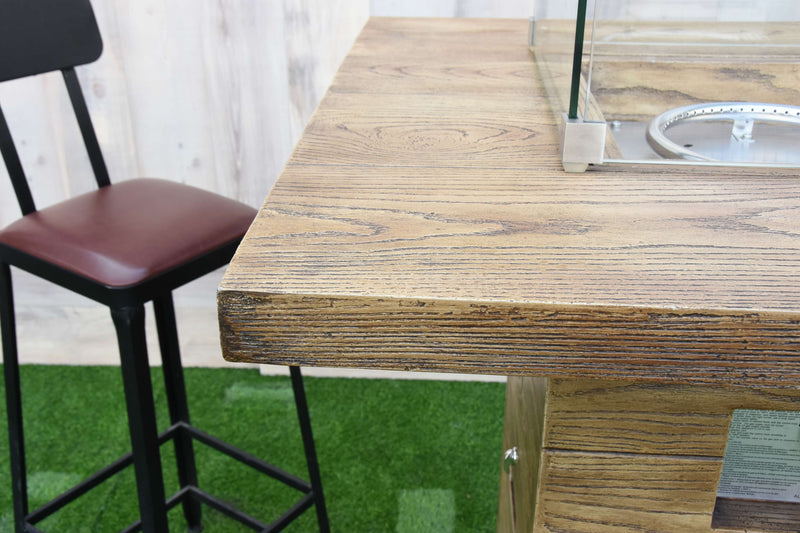 Wooden bar table with a high chair on a green surface