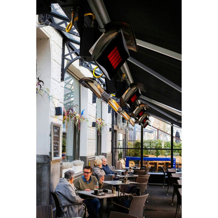 People sitting at tables outside a modern restaurant with large windows below mounted Platinum Gas Heaters