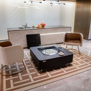Modern living room with a coffee table, chairs, and a kitchen in the background.