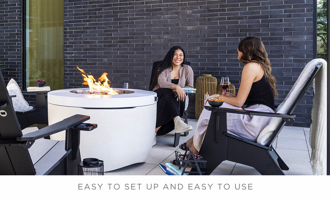 Two women sitting beside the Halo Firepit having a friendly conversation. 