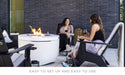 Two women sitting beside the Halo Firepit having a friendly conversation. 