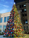 Decorated Christmas tree with colorful ornaments in front of a building