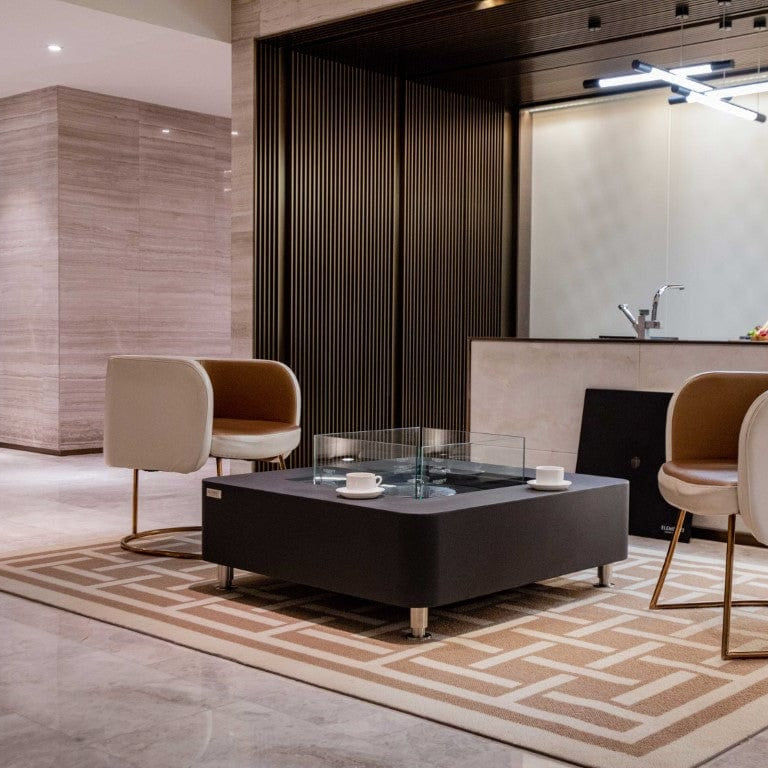 Modern living room with a perth coffee table, chairs, and a kitchen in the background.