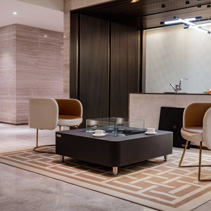 Modern living room with a perth coffee table, chairs, and a kitchen in the background.