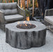 Outdoor patio setting with a fire pit table and wicker chairs.
