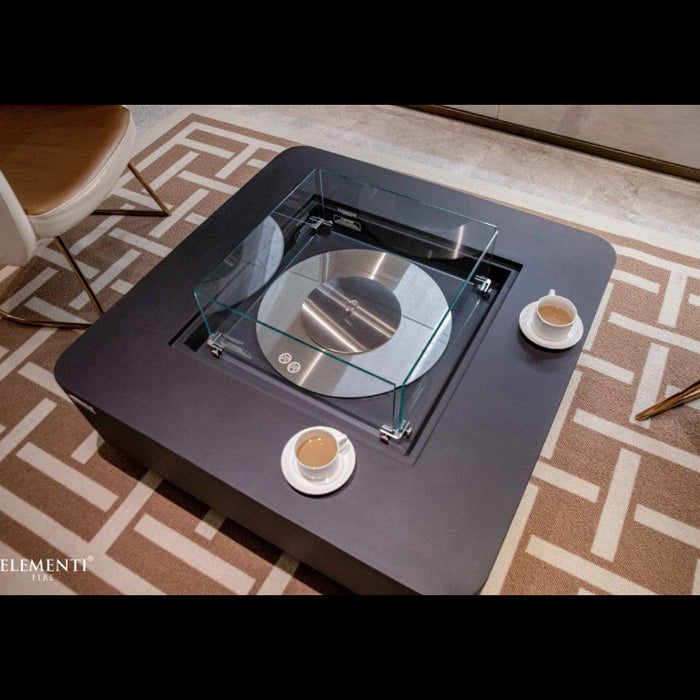 Modern perth fire table with glass top on a patterned rug, featuring Elementi logo.