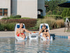 Two people sitting in TenJam Laylo Lounger chairs by a pool with a table between them.